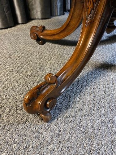 An oval burr walnut coffee table featuring detailed floral marquetry inlays on the tabletop and carved splayed legs. View IV