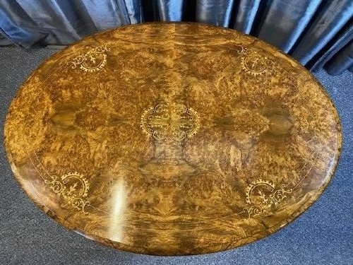 An oval burr walnut coffee table featuring detailed floral marquetry inlays on the tabletop and carved splayed legs. View II