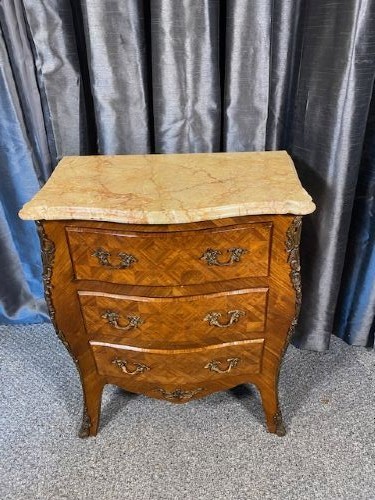 A French Louis XV style serpentine chest of drawers featuring a marble top, parquetry veneer, three drawers with brass handles, and gilt corner mounts. View II