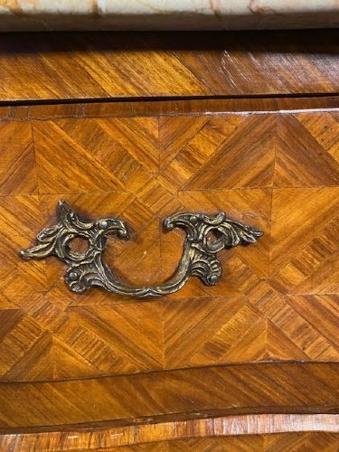 A French Louis XV style serpentine chest of drawers featuring a marble top, parquetry veneer, three drawers with brass handles, and gilt corner mounts. View IV
