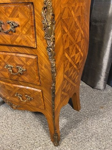 A French Louis XV style serpentine chest of drawers featuring a marble top, parquetry veneer, three drawers with brass handles, and gilt corner mounts. View VI