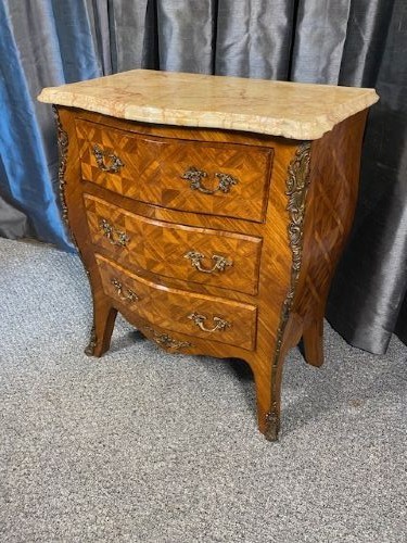 A French Louis XV style serpentine chest of drawers featuring a marble top, parquetry veneer, three drawers with brass handles, and gilt corner mounts. View VIII