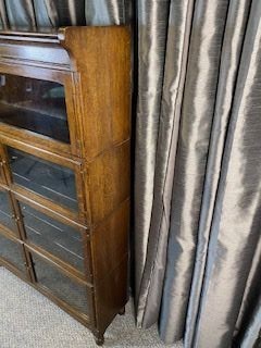 An Edwardian medium brown oak four-tier bookcase featuring glazed double doors on each shelf and a moulded top cornice. View V