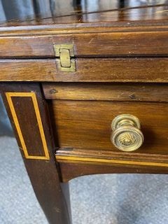 An Edwardian mahogany envelope card table featuring floral marquetry inlay on four folding flaps, a single drawer with brass knobs, and square tapered legs. View VI