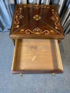 An Edwardian mahogany envelope card table featuring floral marquetry inlay on four folding flaps, a single drawer with brass knobs, and square tapered legs. View VII