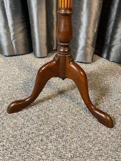 An antique warm brown mahogany wine table featuring a circular top with satinwood central inlay and a fluted turned pedestal resting on three cabriole legs. View IV