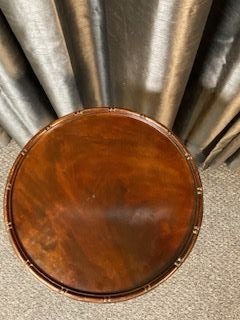 A small mahogany wine table featuring a circular top with a raised rim, supported by a central turned pedestal and a tripod base with cabriole legs. View II