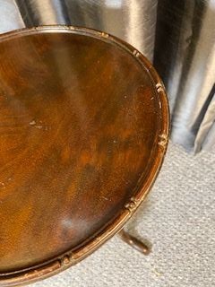 A small mahogany wine table featuring a circular top with a raised rim, supported by a central turned pedestal and a tripod base with cabriole legs. View IV