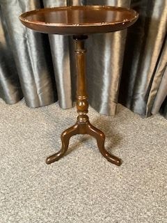 A mahogany tripod wine table featuring a dished circular top, a turned central pedestal column, and three splayed cabriole legs.