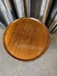 A mahogany tripod wine table featuring a dished circular top, a turned central pedestal column, and three splayed cabriole legs. View II