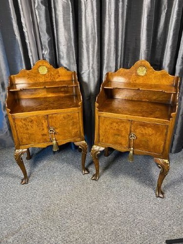 A matching pair of burr walnut bedside cabinets featuring shaped galleried shelf tops, shell carvings, double cupboard doors, and cabriole legs.