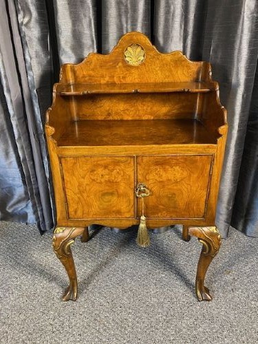 A matching pair of burr walnut bedside cabinets featuring shaped galleried shelf tops, shell carvings, double cupboard doors, and cabriole legs. View IV