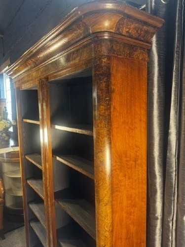 A large double-bay open bookcase made of burr walnut veneer with a moulded top cornice and dark interior shelving. View IV