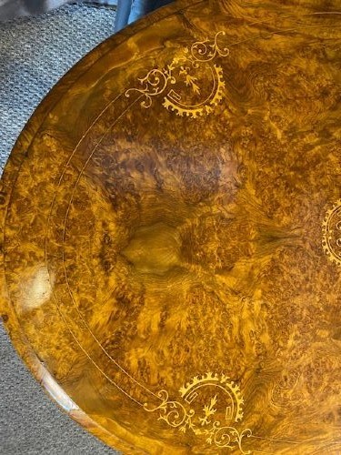 An oval burr walnut coffee table featuring floral marquetry inlay, a moulded rim, and carved splayed legs. View III
