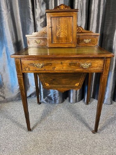 A matching pair of antique rosewood writing desks featuring inlaid boxwood marquetry, green leather tops, raised central cabinets, and tapered legs with brass castors. View II