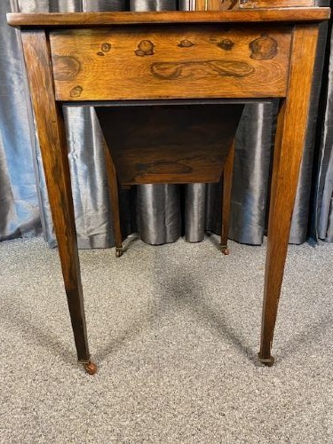 A matching pair of antique rosewood writing desks featuring inlaid boxwood marquetry, green leather tops, raised central cabinets, and tapered legs with brass castors. View V