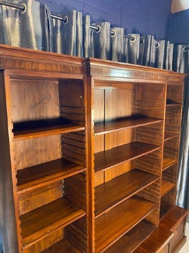 A large Victorian mahogany open breakfront bookcase featuring three sectioned shelving units over a low plinth cabinet base. View IV