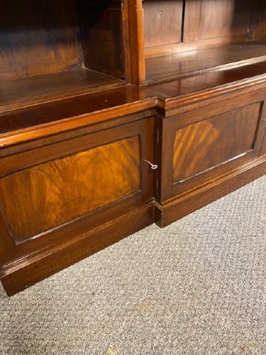 A large Victorian mahogany open breakfront bookcase featuring three sectioned shelving units over a low plinth cabinet base. View VI