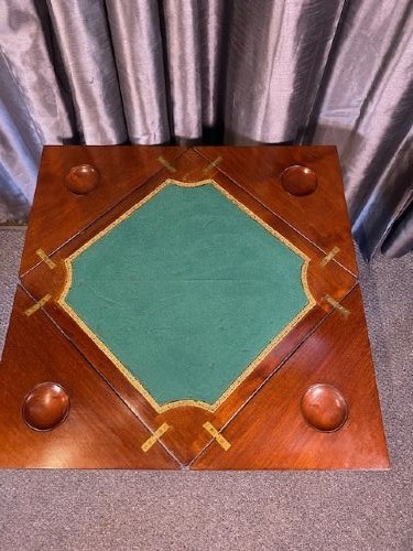 An Edwardian mahogany envelope card table featuring marquetry floral inlay on four triangular folding top leaves, a single drawer with brass handles, and square tapered legs. View V