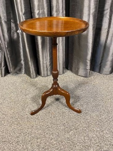 A circular mahogany wine table featuring a moulded dished top, a turned baluster stem, and a three-legged cabriole tripod base.