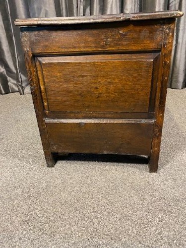 A dark oak coffer featuring three carved lozenge panels, a carved top rail, turned stiles, and a hinged rectangular top. View V