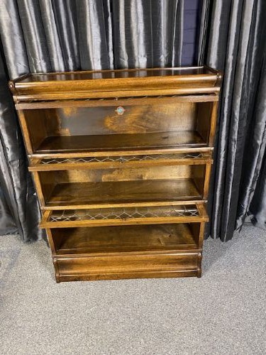 A three-tier antique wooden Globe Wernicke stacking bookcase with detailed leaded glass door panels. View II