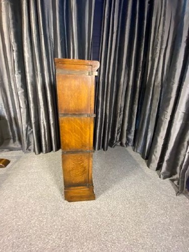 A three-tier antique wooden Globe Wernicke stacking bookcase with detailed leaded glass door panels. View V