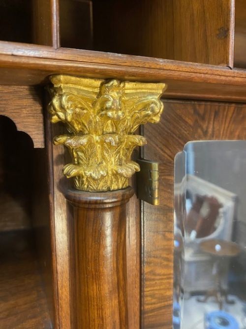 An antique walnut bureau bookcase featuring a broken arch pediment, double mirrored cabinet doors, a slant-front writing slope, and several drawers with brass handles. View VI