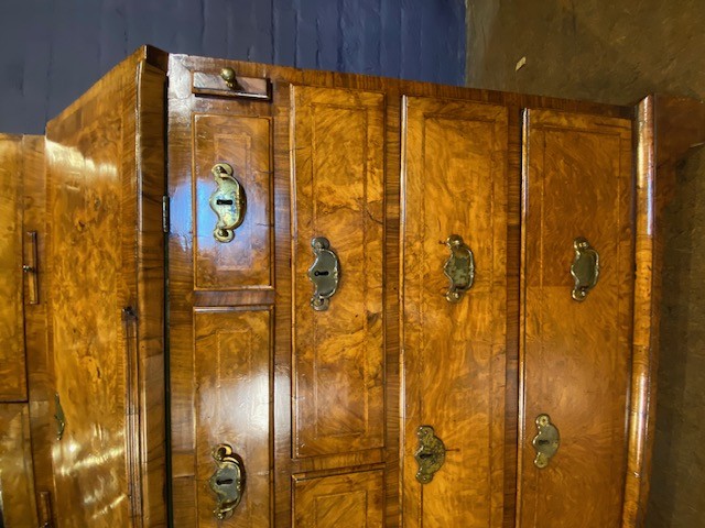 An antique walnut bureau bookcase featuring a broken arch pediment, double mirrored cabinet doors, a slant-front writing slope, and several drawers with brass handles. View XII