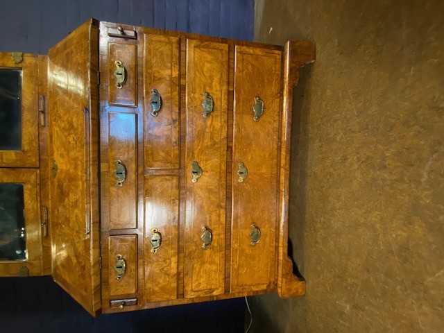 An antique walnut bureau bookcase featuring a broken arch pediment, double mirrored cabinet doors, a slant-front writing slope, and several drawers with brass handles. View XIV