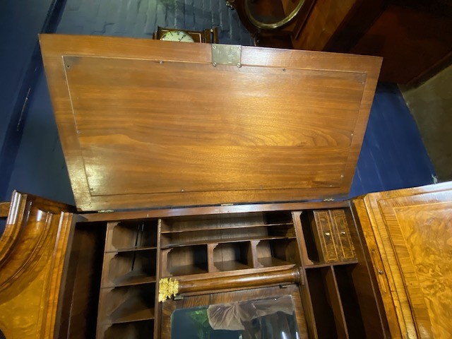 An antique walnut bureau bookcase featuring a broken arch pediment, double mirrored cabinet doors, a slant-front writing slope, and several drawers with brass handles. View XV