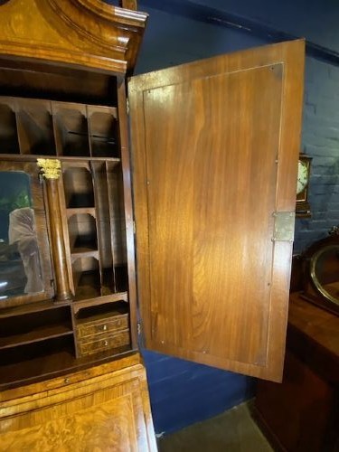 An antique walnut bureau bookcase featuring a broken arch pediment, double mirrored cabinet doors, a slant-front writing slope, and several drawers with brass handles. View XV
