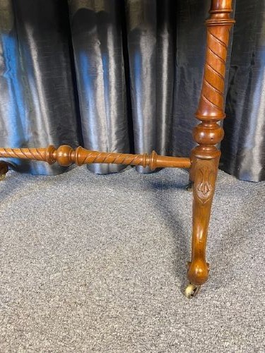 An antique kidney-shaped walnut writing desk featuring an inset green leather writing surface, frieze drawers, turned legs, and a stretcher base. View VIII