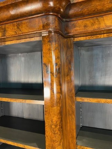 A large Victorian burr walnut breakfront bookcase featuring open adjustable shelves and a dark painted interior. View V