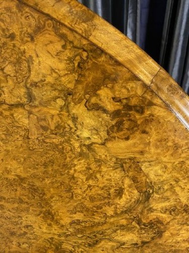 A circular Victorian burr walnut tilt-top table displaying book-matched veneer figure, supported by a carved tripod pedestal base. View III