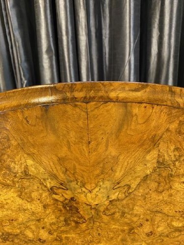 A circular Victorian burr walnut tilt-top table displaying book-matched veneer figure, supported by a carved tripod pedestal base. View IV