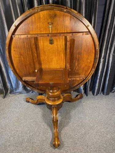 A circular Victorian burr walnut tilt-top table displaying book-matched veneer figure, supported by a carved tripod pedestal base. View VI