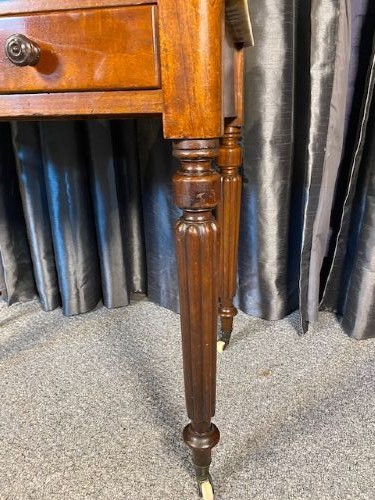 A Victorian mahogany washstand featuring a white marble top with splashback, twin drawers, and turned reeded legs on brass castors. View III