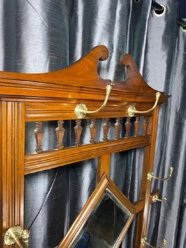 A tall walnut hall stand featuring a top scrolled crest, brass hooks, a diamond-shaped central mirror, blue ceramic tiles, a glove drawer, and umbrella holders with drip trays. View III