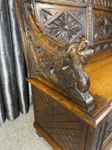A dark carved oak storage bench featuring a high backrest with geometric floral panels and a enclosed box seat base. View III