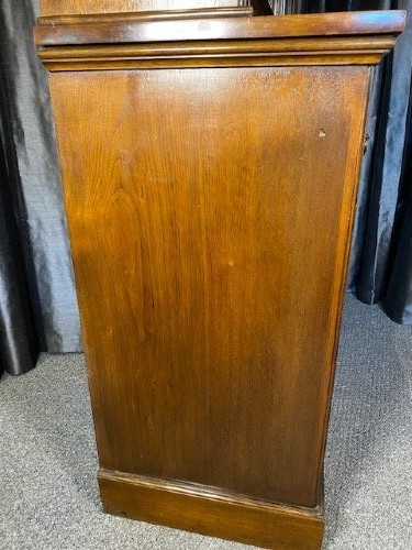 A tall Victorian walnut bookcase featuring a two-door glazed upper display section, two middle drawers with metal handles, and carved panel doors at the base. View V