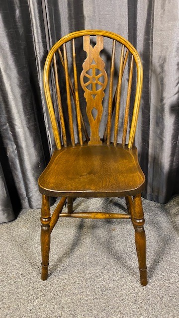 A set of six brown wooden Windsor dining chairs with hoop backs, pierced wheelback central splats, and turned legs. View II