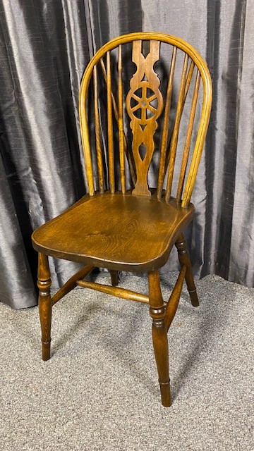 A set of six brown wooden Windsor dining chairs with hoop backs, pierced wheelback central splats, and turned legs. View III