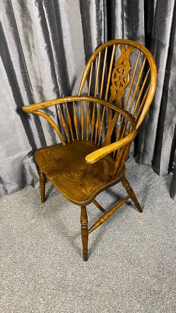 A set of six brown wooden Windsor dining chairs with hoop backs, pierced wheelback central splats, and turned legs. View IV