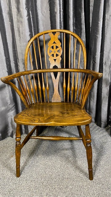 A set of six brown wooden Windsor dining chairs with hoop backs, pierced wheelback central splats, and turned legs. View V