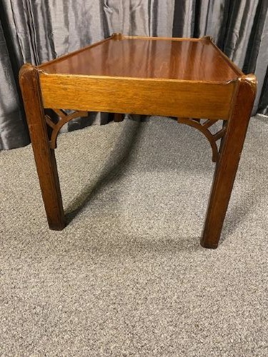 A low rectangular mahogany coffee table featuring a raised gallery rim and decorative pierced fretwork corner brackets on square legs. View II