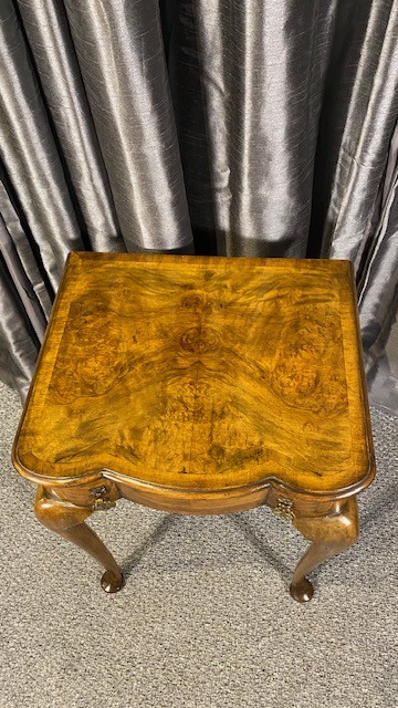 A Queen Anne style walnut occasional table featuring slender cabriole legs, pad feet, and a single drawer fitted with two ornate brass drop handles. View III