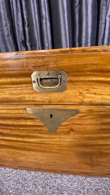 A rectangular camphor wood military campaign chest featuring brass corner brackets, flush brass handles, and a central brass keyhole escutcheon. View II
