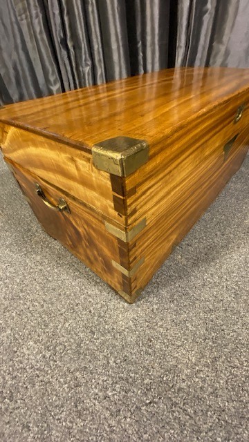 A rectangular camphor wood military campaign chest featuring brass corner brackets, flush brass handles, and a central brass keyhole escutcheon. View V