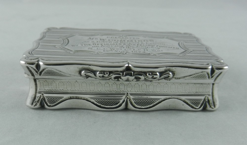 An engraved rectangular Victorian sterling silver snuff box with scalloped edges and a presentation inscription on the lid. View V